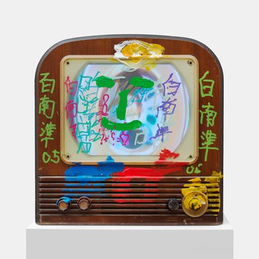 木制老式电视，外观和屏幕上都涂着彩色油漆，包括汉字