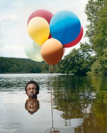 男孩被淹没在水里的彩色气球的图像